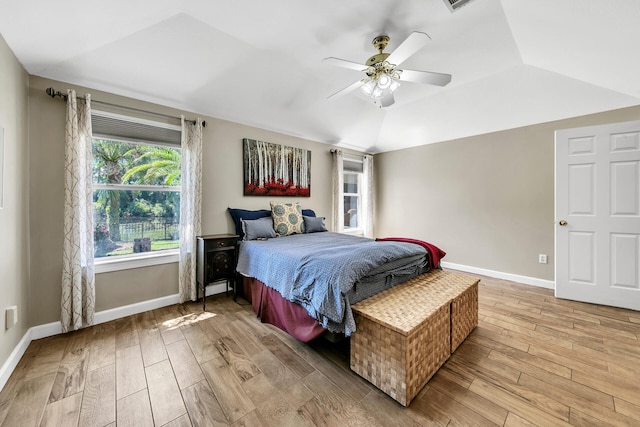 bedroom with ceiling fan, vaulted ceiling, and light hardwood / wood-style floors