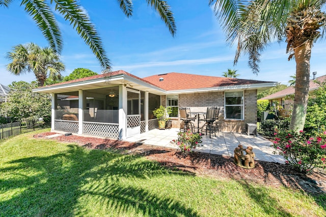 rear view of property featuring a sunroom, a yard, and a patio