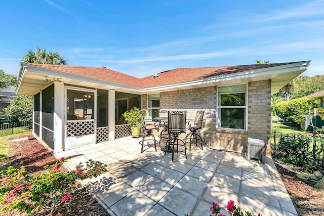 back of property with a sunroom and a patio area