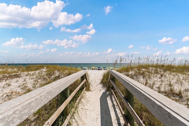 view of home's community featuring a water view and a beach view