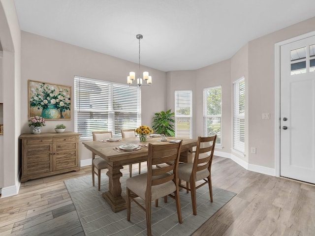 dining area featuring light hardwood / wood-style flooring and a chandelier