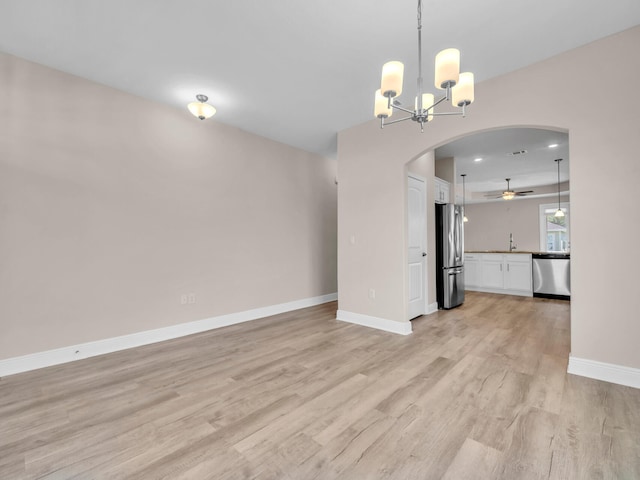 interior space with ceiling fan with notable chandelier, light wood-type flooring, and sink