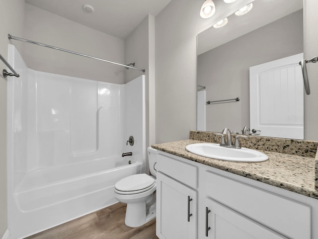 full bathroom with bathtub / shower combination, vanity, hardwood / wood-style floors, and toilet