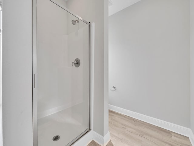 bathroom with hardwood / wood-style floors and a shower with door