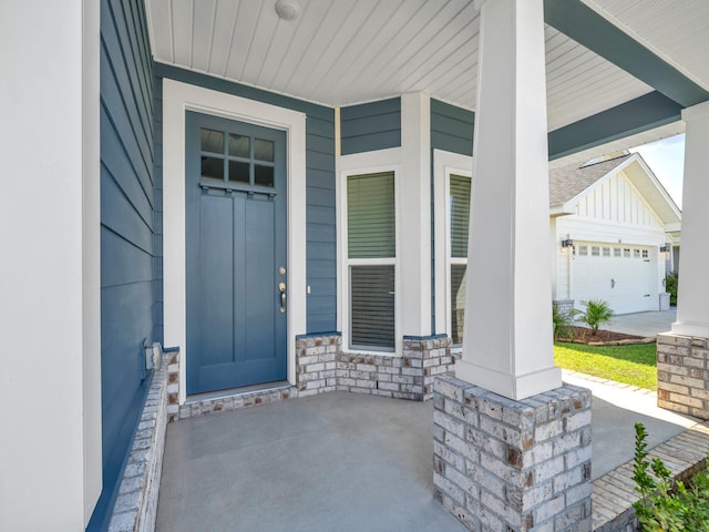 view of exterior entry featuring a garage and a porch