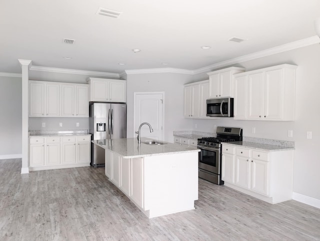 kitchen featuring a kitchen island with sink, appliances with stainless steel finishes, light wood-type flooring, and white cabinets