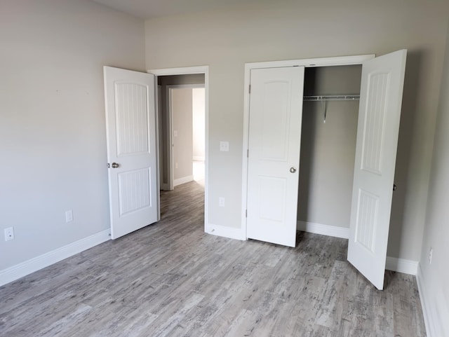 unfurnished bedroom with light hardwood / wood-style flooring and a closet