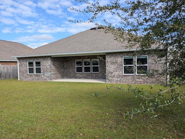 rear view of house with a yard and a patio