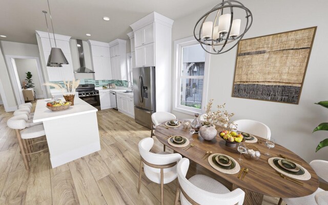 kitchen with wall chimney range hood, decorative light fixtures, stainless steel appliances, and white cabinets