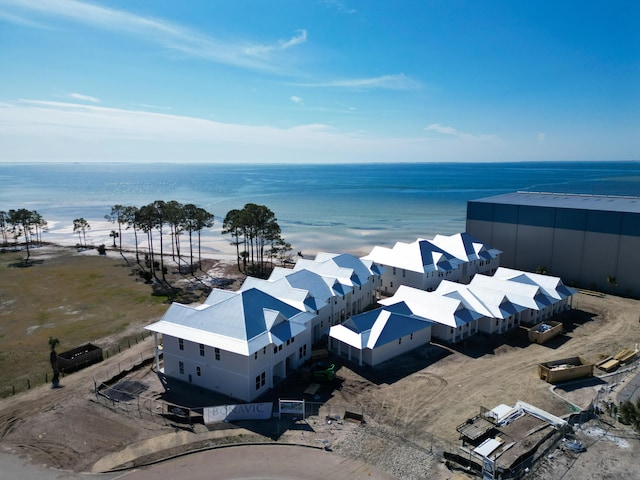 birds eye view of property with a water view and a beach view