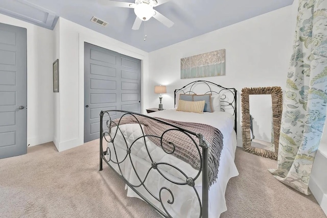 bedroom with light colored carpet, ceiling fan, and a closet