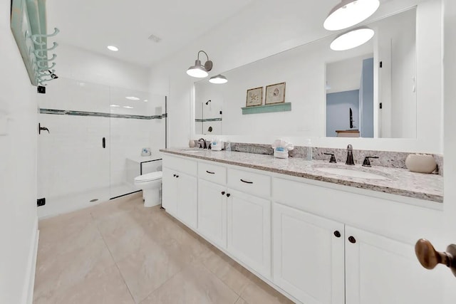 bathroom with toilet, vanity, tile patterned flooring, and a shower with shower door