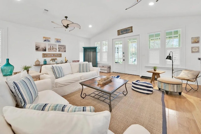 living room with lofted ceiling, french doors, and light hardwood / wood-style floors