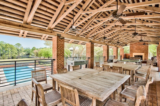 view of patio featuring a gazebo, ceiling fan, and an outdoor brick fireplace