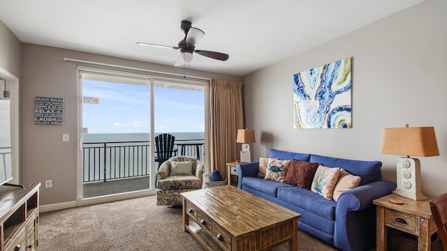 carpeted living room with a water view and ceiling fan