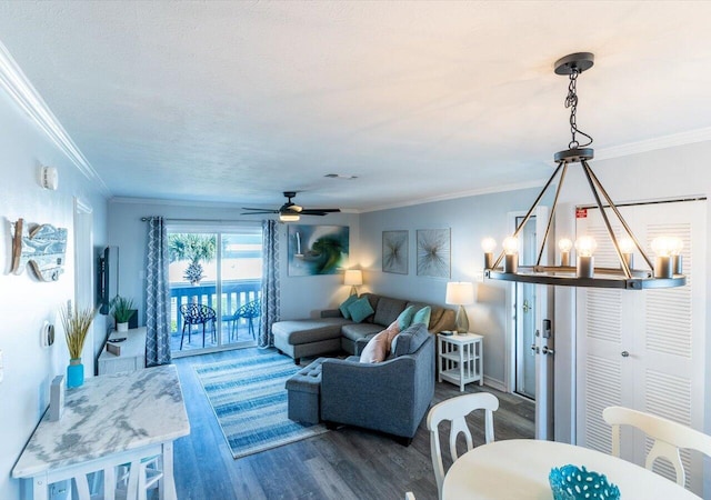 living room with ornamental molding, ceiling fan with notable chandelier, and dark hardwood / wood-style flooring