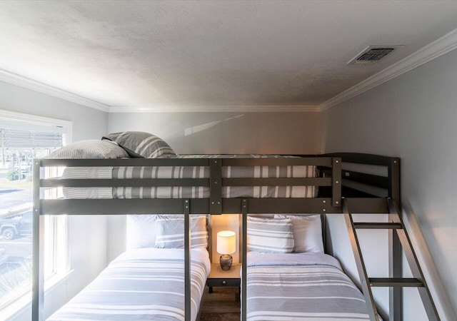 bedroom featuring a textured ceiling, crown molding, and dark hardwood / wood-style floors