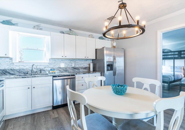 kitchen with a notable chandelier, stainless steel appliances, and white cabinets