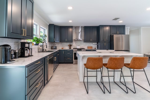 kitchen featuring appliances with stainless steel finishes, backsplash, a kitchen island, crown molding, and wall chimney range hood