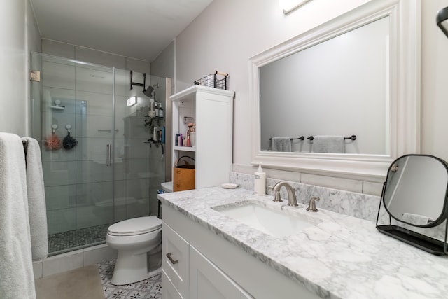 bathroom featuring tile patterned floors, walk in shower, vanity, and toilet