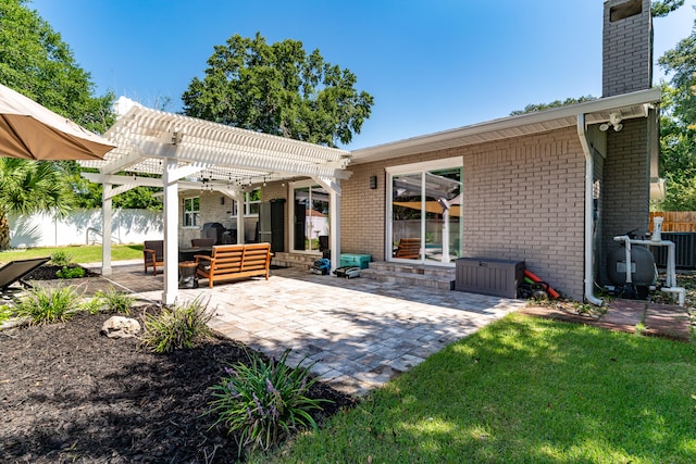 back of house featuring a pergola, a patio, outdoor lounge area, central AC, and a yard