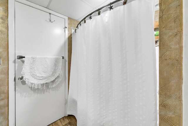 bathroom featuring wood-type flooring and curtained shower