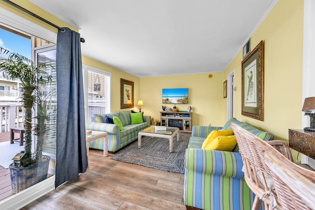 living room with crown molding, hardwood / wood-style floors, and a wealth of natural light