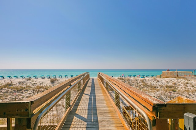 view of home's community with a water view and a beach view