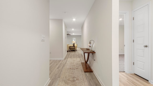 hall with baseboards, recessed lighting, and light wood-style floors