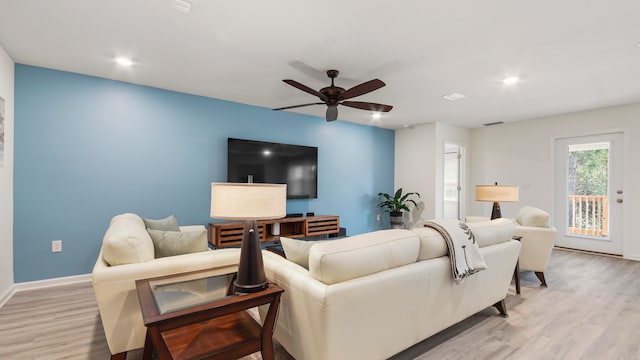 living room featuring ceiling fan and light hardwood / wood-style floors