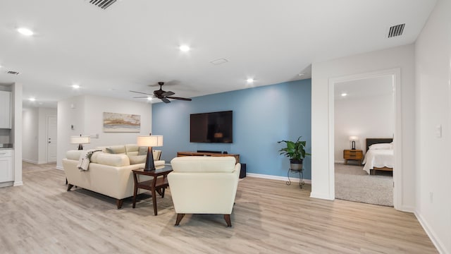 living room featuring ceiling fan and light hardwood / wood-style flooring