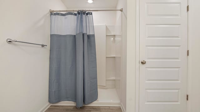 bathroom featuring hardwood / wood-style flooring and a shower with curtain