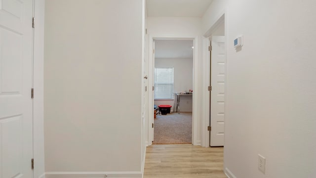 hallway with light hardwood / wood-style floors