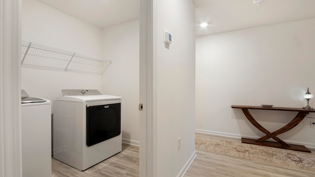 laundry room featuring independent washer and dryer and light wood-type flooring