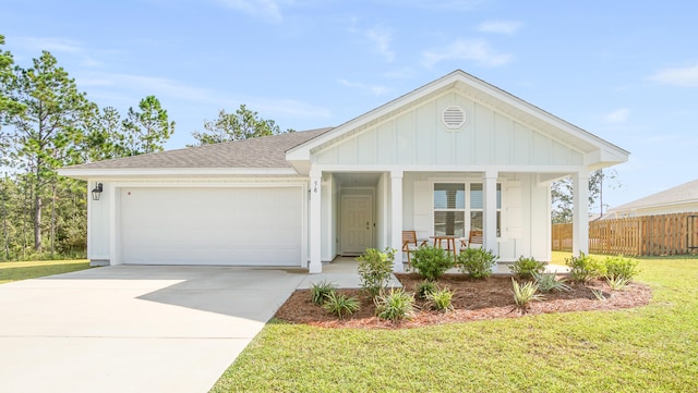 view of front of house featuring a garage, a front lawn, and covered porch