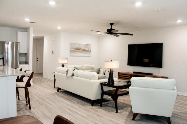 living area featuring recessed lighting, visible vents, ceiling fan, light wood-type flooring, and baseboards