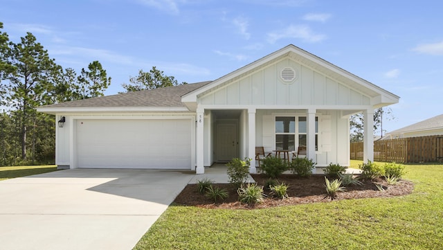 view of front facade featuring covered porch, an attached garage, board and batten siding, fence, and driveway