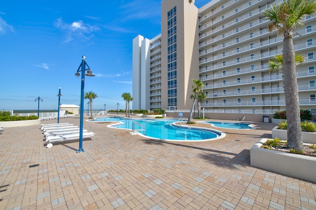 view of swimming pool with a patio and a hot tub