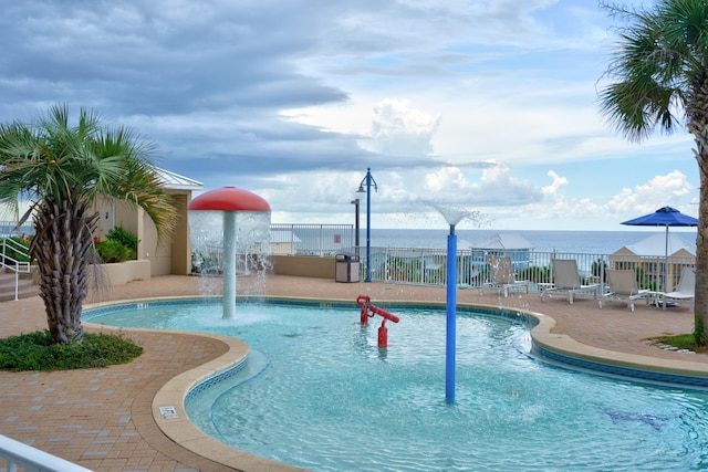 view of swimming pool featuring pool water feature, a patio, and a water view