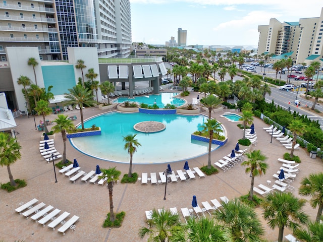 view of swimming pool featuring a patio and a hot tub