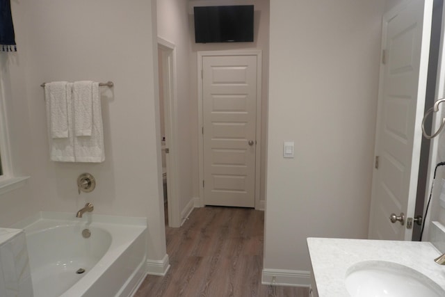 bathroom featuring vanity, hardwood / wood-style flooring, and a bathtub