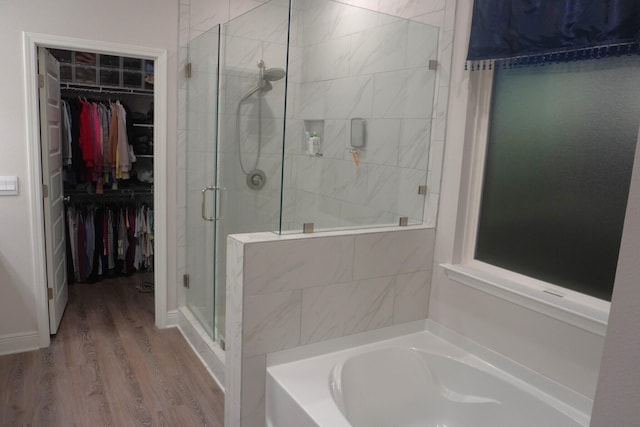 bathroom with independent shower and bath and hardwood / wood-style floors