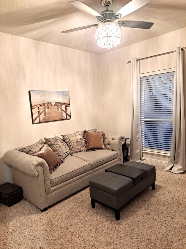 living room featuring carpet, ceiling fan, and a textured ceiling