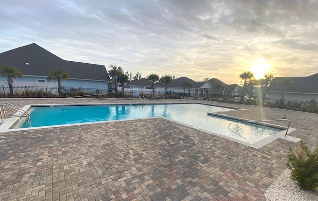 pool at dusk with a patio