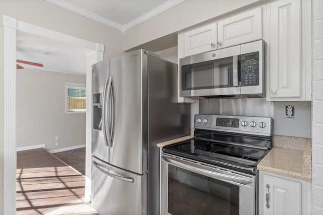 kitchen featuring appliances with stainless steel finishes, white cabinetry, ceiling fan, crown molding, and light stone countertops