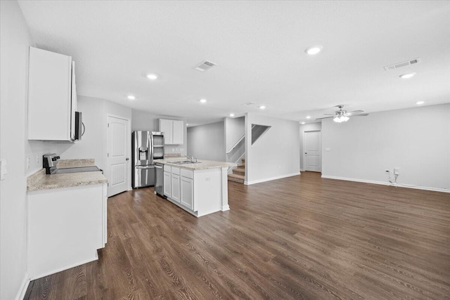 kitchen with dark wood-type flooring, a center island with sink, ceiling fan, white cabinetry, and stainless steel appliances