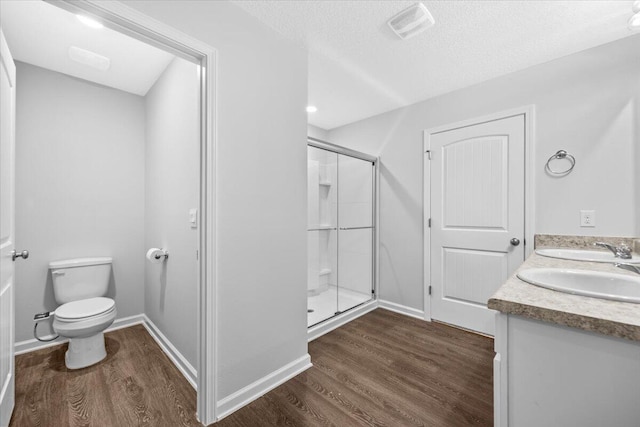 bathroom featuring hardwood / wood-style floors, an enclosed shower, and toilet