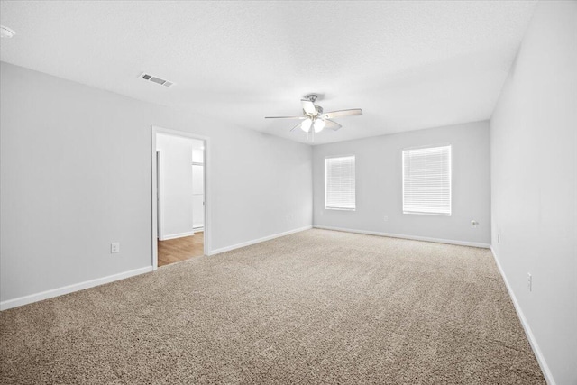 carpeted spare room with a textured ceiling and ceiling fan