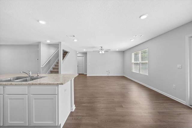 kitchen with white cabinetry, sink, ceiling fan, dark hardwood / wood-style flooring, and a textured ceiling