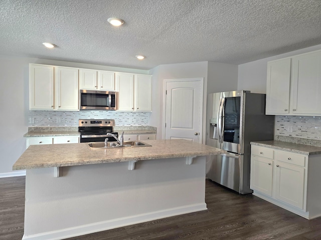 kitchen with white cabinetry, stainless steel appliances, and dark wood-type flooring